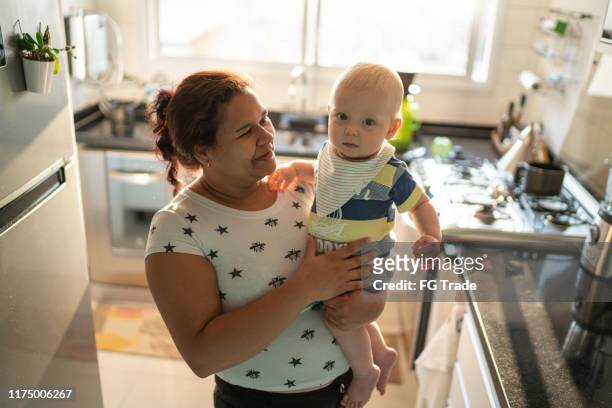 babysitter en baby jongen in de keuken - babysit stockfoto's en -beelden