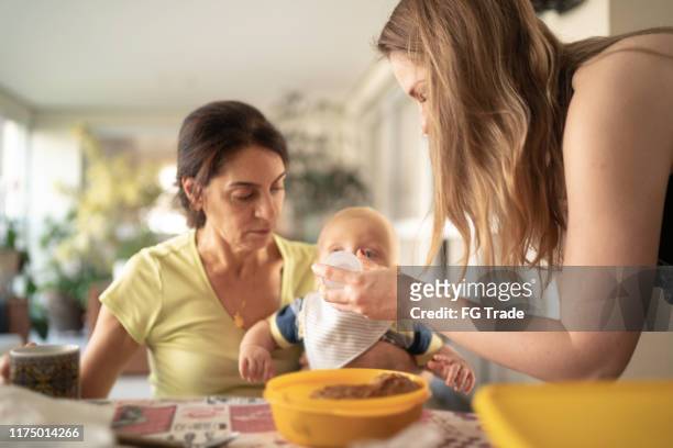 grandmother, mother and grandson having breakfast together - mother in law stock pictures, royalty-free photos & images
