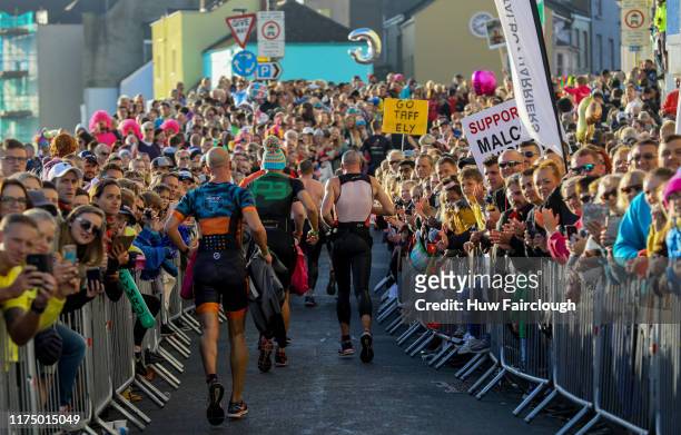 Athletes exit the water and run through Tenby to transition in IRONMAN Wales on on September 15, 2019 in Tenby, Wales.