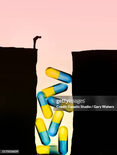 ilustrações, clipart, desenhos animados e ícones de concept image of a man looking down a crevasse at large medicine capsules. - fenda