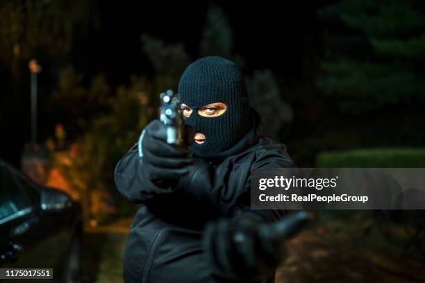 man in huid masker holding gun - bivakmuts stockfoto's en -beelden