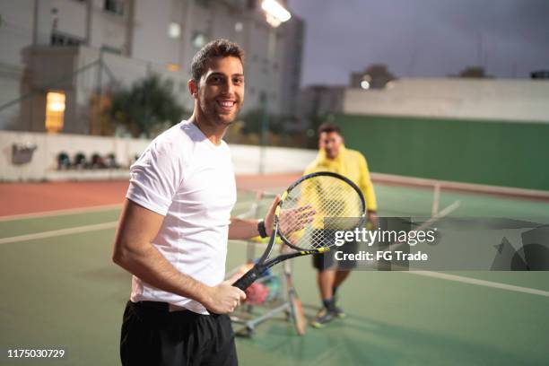 teaching a guy how to play tennis - young tennis player stock pictures, royalty-free photos & images