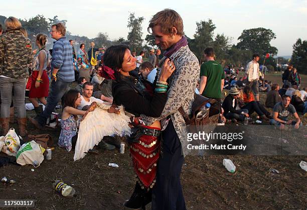 Couple embrace as festival-goers gather to see the sunrise from the Stone Circle area at the Glastonbury Festival site at Worthy Farm, Pilton on June...