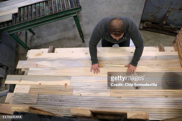The Woodworkers Shoppe employees Michael Yoder stacks sanded boards of custom tongue-and-groove flooring made from mountain pine beetle-killed...