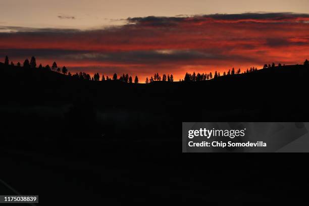 The sun rises behind a ridge of trees September 13, 2019 near Missoula, Montana. According to the 2017 Montana Climate Assessment, the annual average...