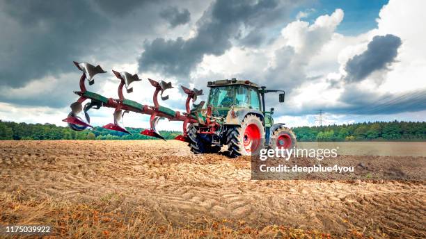 tractor plows the field - ploughed field stock pictures, royalty-free photos & images