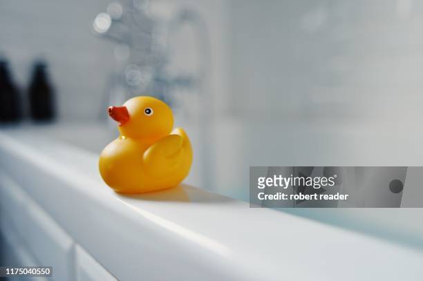 yellow toy rubber duck on side of bath - badanka bildbanksfoton och bilder