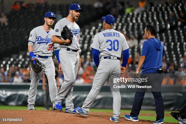 Rich Hill of the Los Angeles Dodgers speaks with manager Dave Roberts during the game against the Baltimore Orioles at Oriole Park at Camden Yards on...