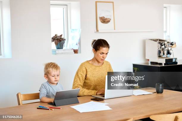 mutter und sohn mit technologien zu hause - unschuld stock-fotos und bilder