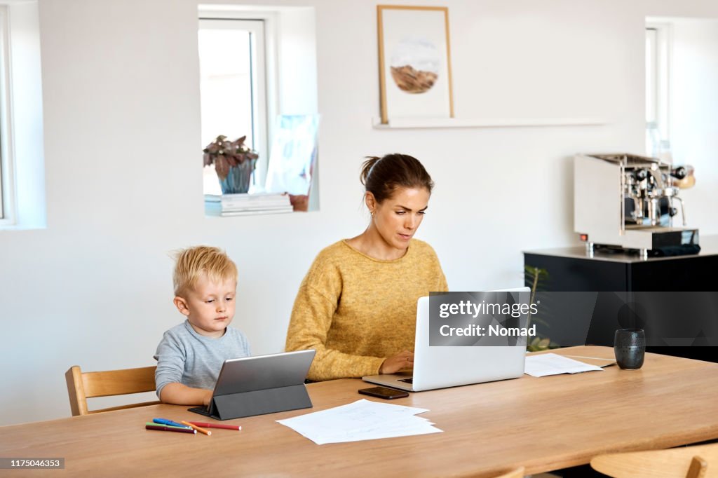 Mother and son using technologies at home