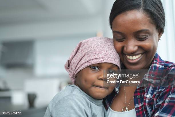 supportive mother holds child with cancer - childhood cancer stock pictures, royalty-free photos & images