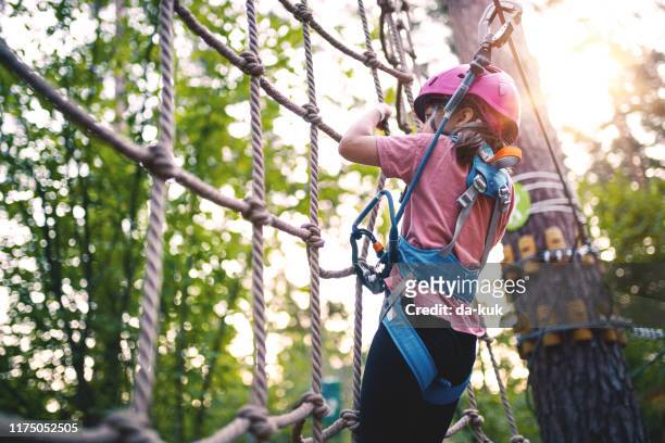 女孩克服障礙在冒險繩索公園 - 樹梢 個照片及圖片檔