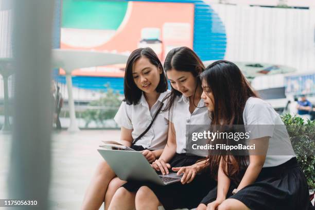 three student friends studying together with a laptop - thai people stock pictures, royalty-free photos & images