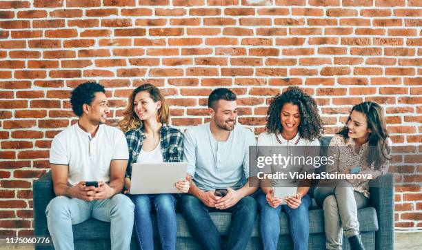 group of people using mobile devices - brick wall business person stock pictures, royalty-free photos & images