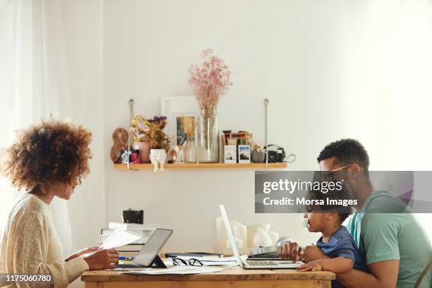 parents utilisant l'ordinateur tout en s'asseyant avec le garçon - boy in briefs photos et images de collection