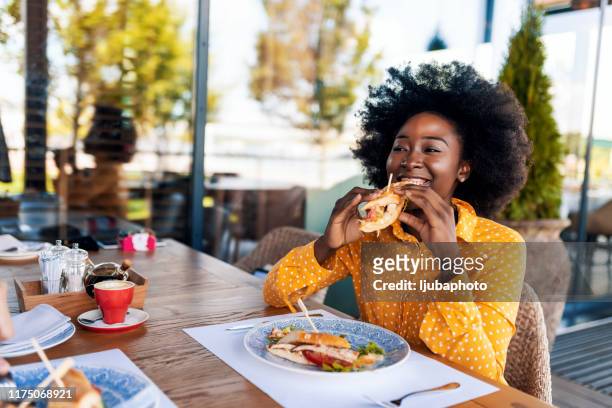 vrouw genieten van sandwich eten in restaurant - eating alone stockfoto's en -beelden