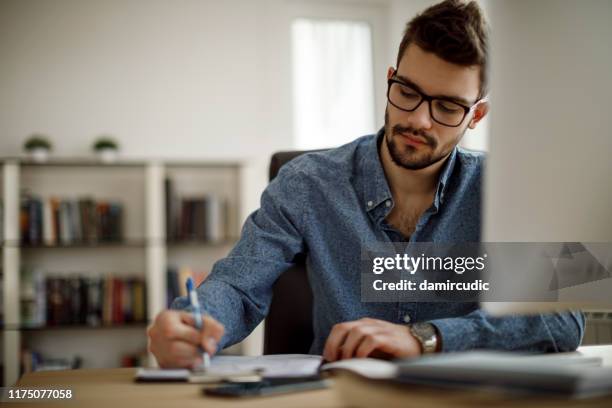 young man working - hand writing imagens e fotografias de stock