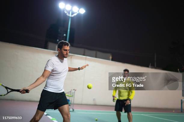 テニスのやり方を男に教える - tennis coaching ストックフォトと画像