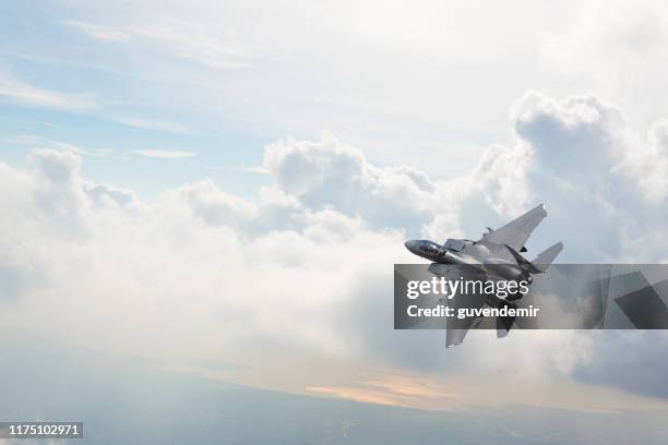 avion de chasse de f-15 volant au-dessus des nuages - avion de chasse photos et images de collection