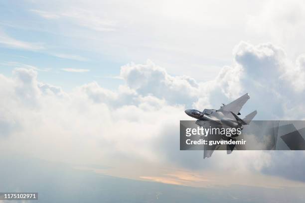 雲の上を飛ぶf-15戦闘機 - 戦闘機 ストックフォトと画像
