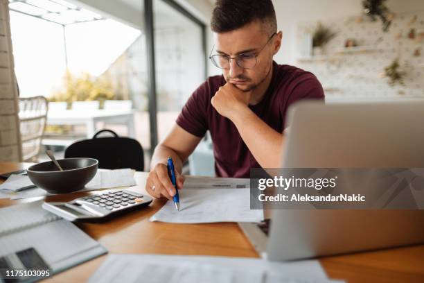 paying bills - home finances man stock pictures, royalty-free photos & images