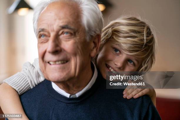 happy grandson hugging grandfather - grandfather face stock-fotos und bilder