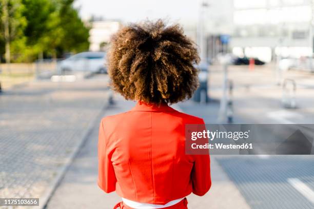 back view of young woman wearing fashionable red suit jacket - afro stock-fotos und bilder