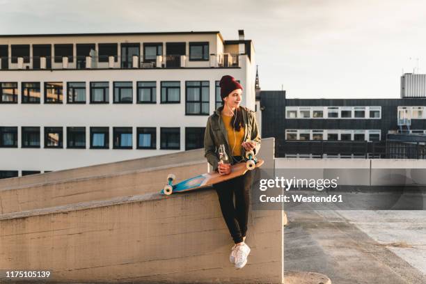 stylish young woman with skateboard on parking deck - skateboard deck stock pictures, royalty-free photos & images