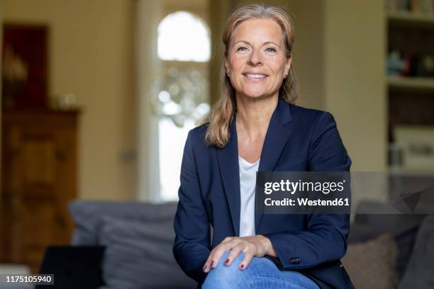 portrait of smiling mature businesswoman at home - exclusive foto e immagini stock