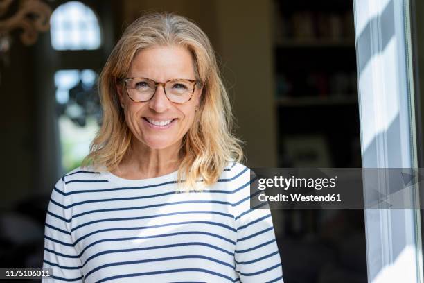 portrait of smiling mature woman wearing glasses - 45 year old woman stock pictures, royalty-free photos & images