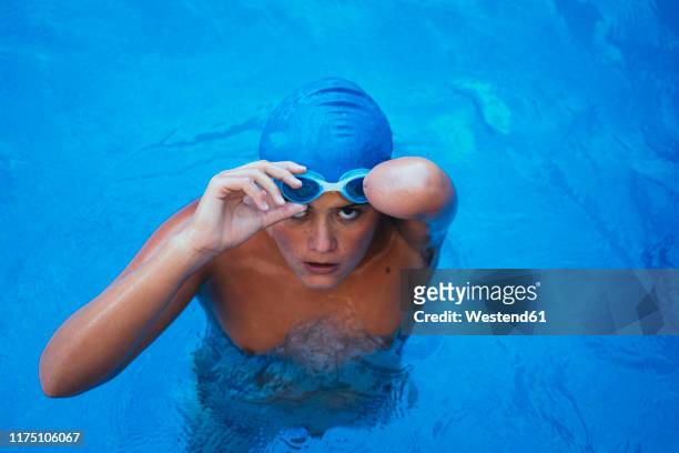 portrait of young paralympic swimmer putting on swimmming goggles - sport venue stock pictures, royalty-free photos & images