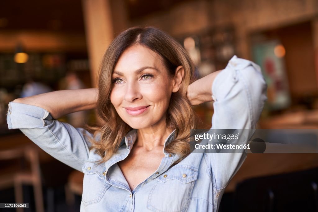 Business woman in a cafe, hands on the neck