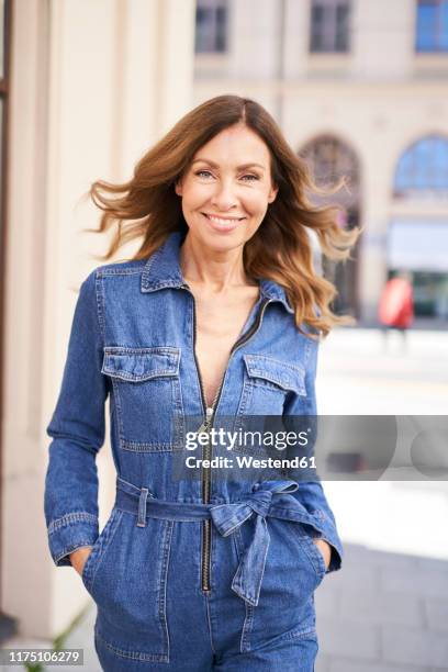 mature woman wearing denim jumpsuit - jumpsuit stock pictures, royalty-free photos & images