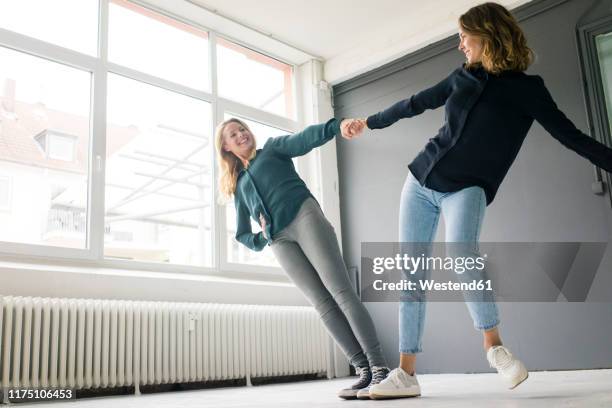 two young women supporting each other playfully - reliable bildbanksfoton och bilder