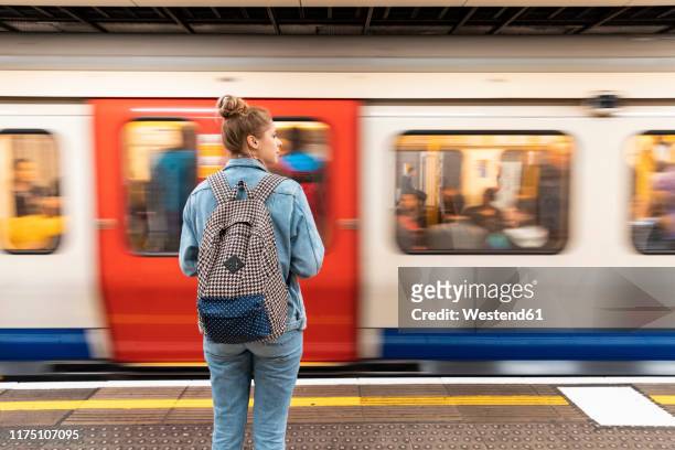 rear view of young woman at subway station with incoming train - london underground 個照片及圖片檔