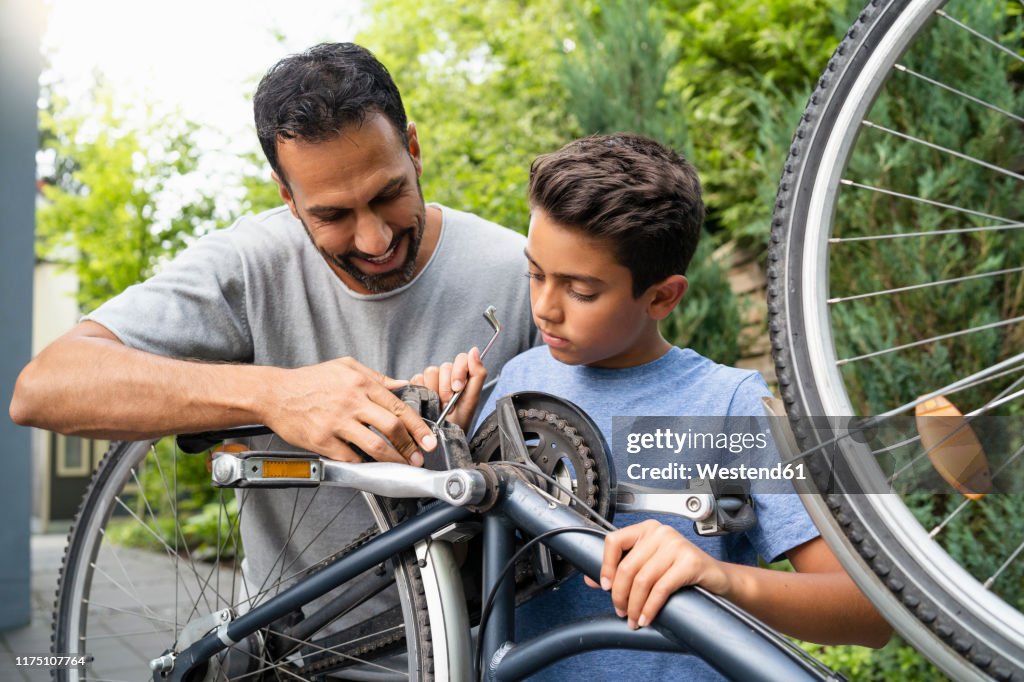 Father and son repairing bicycle together