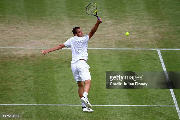Mikhail Youzhny of Russia reaches for a shot during his fourth round match against Roger Federer of Switzerland on Day Seven of the Wimbledon Lawn...