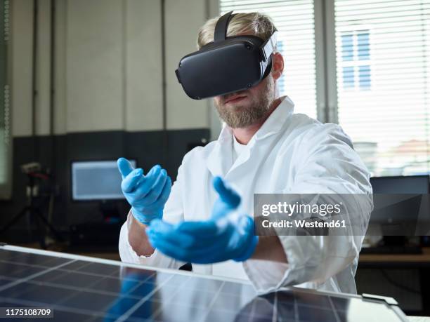 technician with vr glasses and solar panel in lab - product design stock-fotos und bilder