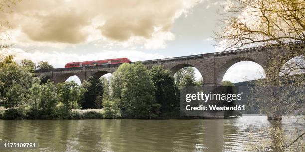 regional train crossing river ruhr on a viaduct, herdecke, germany - ruhr stock-fotos und bilder