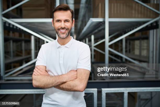 portrait of smiling man in a factory - polohemd stock-fotos und bilder