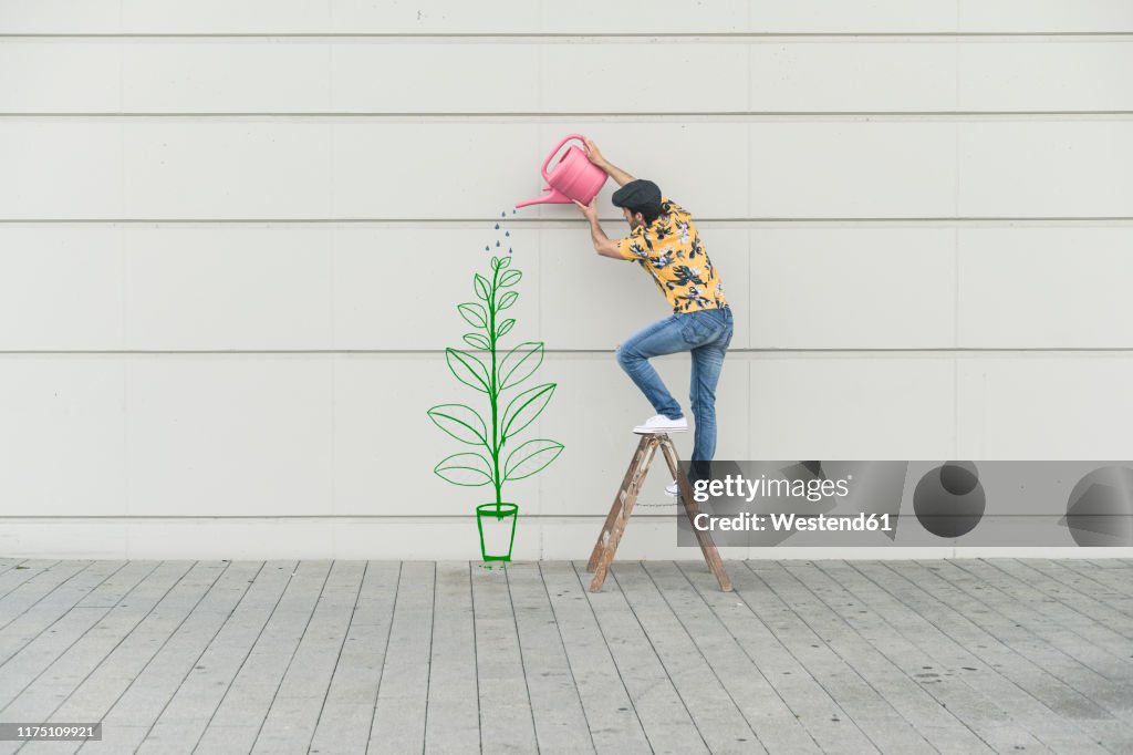 Digital composite of young man watering flower at a wall