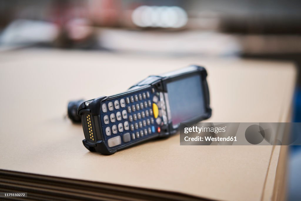 Barcode scanner lying on cardbox in factory