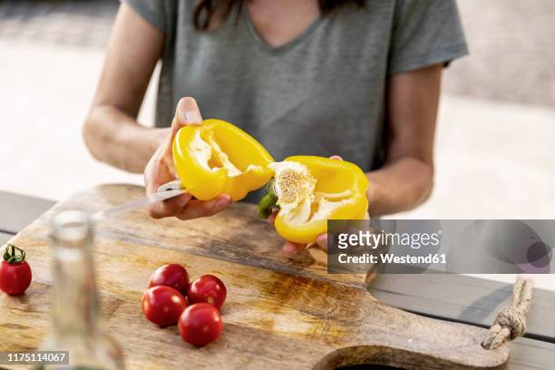 close-up of woman preparing healthy food outdoors - gele paprika stockfoto's en -beelden