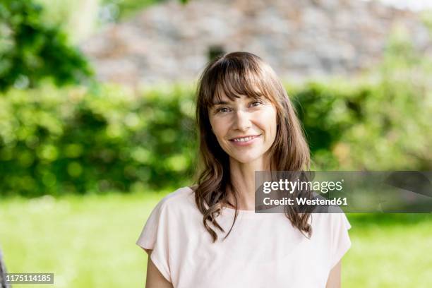 portrait of smiling brunette woman outdoors - shirt stock-fotos und bilder