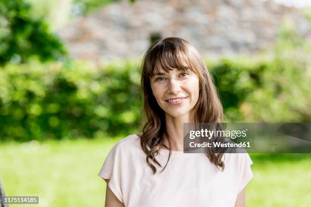 portrait of smiling brunette woman outdoors - woman white shirt stock-fotos und bilder