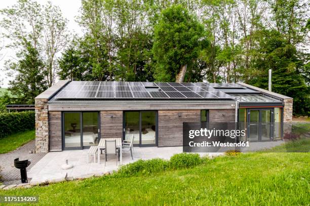detached house with solar panels on the roof - einfamilienhaus mit solarzellen stock-fotos und bilder