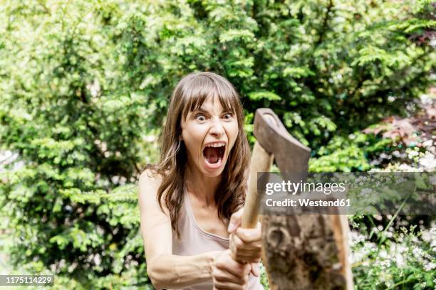 screaming woman chopping wood - hysteria stock-fotos und bilder