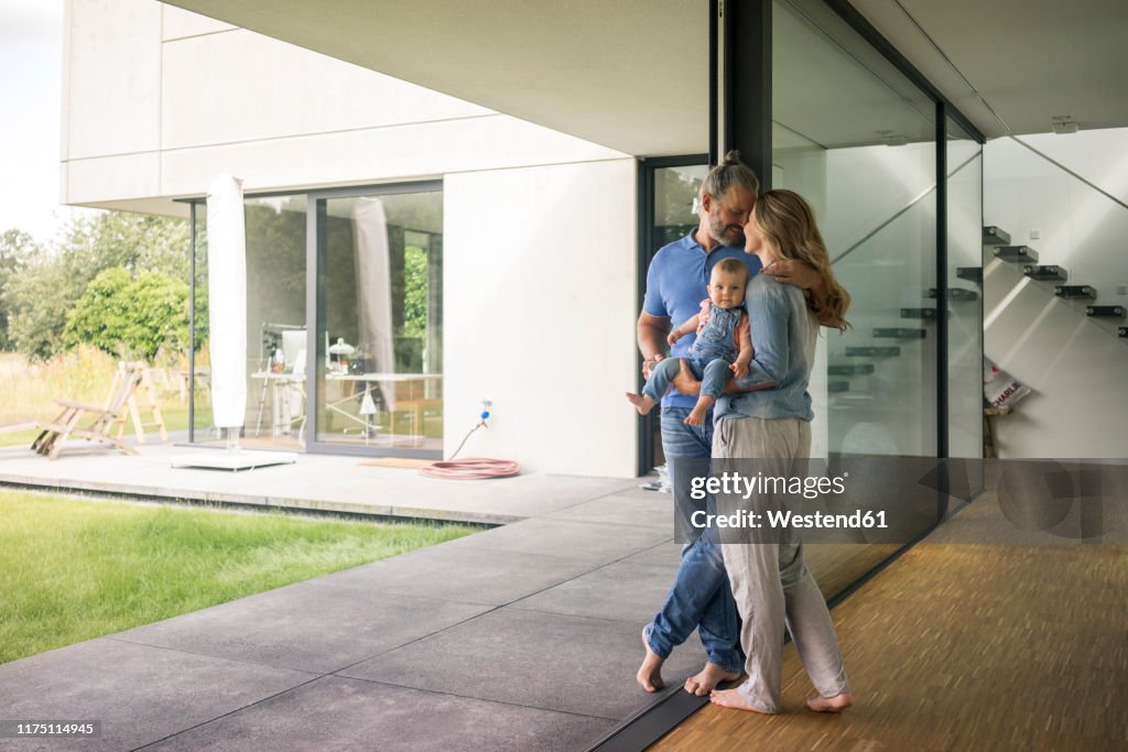 Family of three standing at the window at home