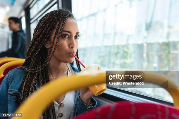 young woman in a bus in the city drinking a fresh juice, london, uk - staring up stock pictures, royalty-free photos & images