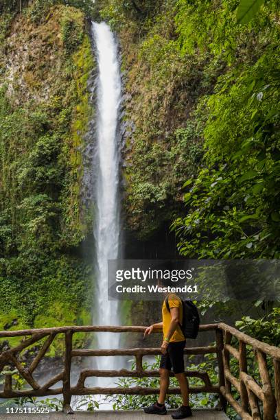 traveller visiting la fortuna waterfall, la fortuna, costa rica - costa rica waterfall stock pictures, royalty-free photos & images